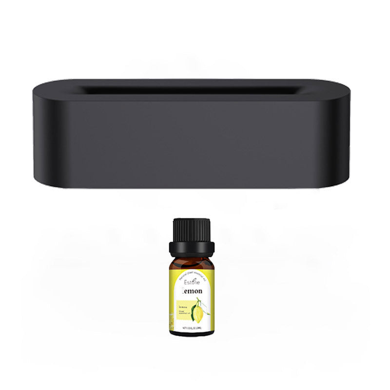 Sleek black aroma diffuser with essential oil bottle, creating a calming atmosphere.