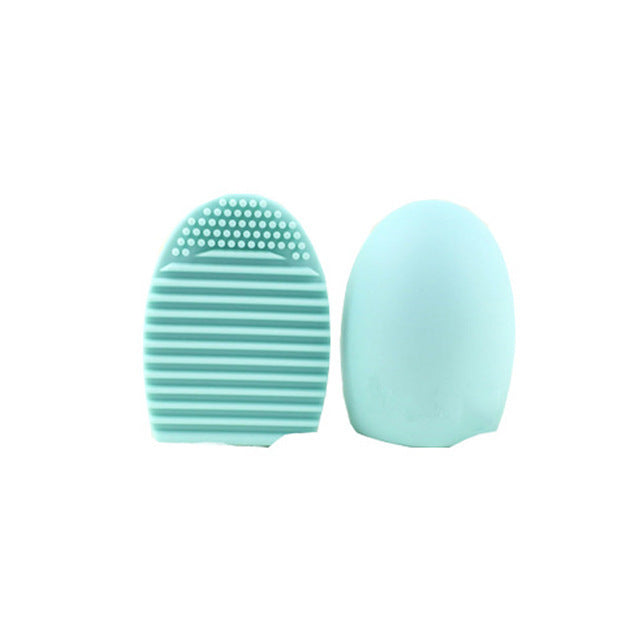 Mint green silicone makeup brush cleaner and egg-shaped makeup sponge applicator on white background