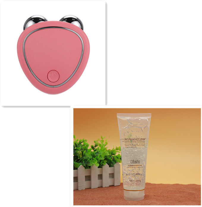 Portable facial micro-current beauty instrument for lifting, thinning, and reducing edema with double roller massager in pink color, displayed with a tube of skin care product in the background.