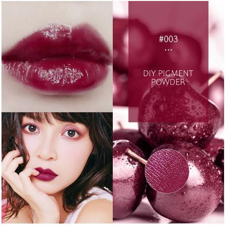 Vibrant burgundy lip gloss with shimmering pigment powder on makeup brushes and applicators, showcasing a bold, glamorous cosmetic look.