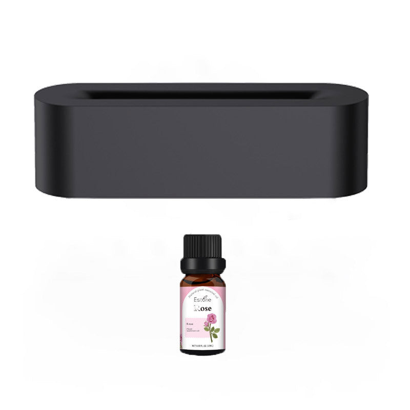 Sleek black ultrasonic aroma diffuser with essential oil bottle, offering a soothing mist and fragrant scent for the home.