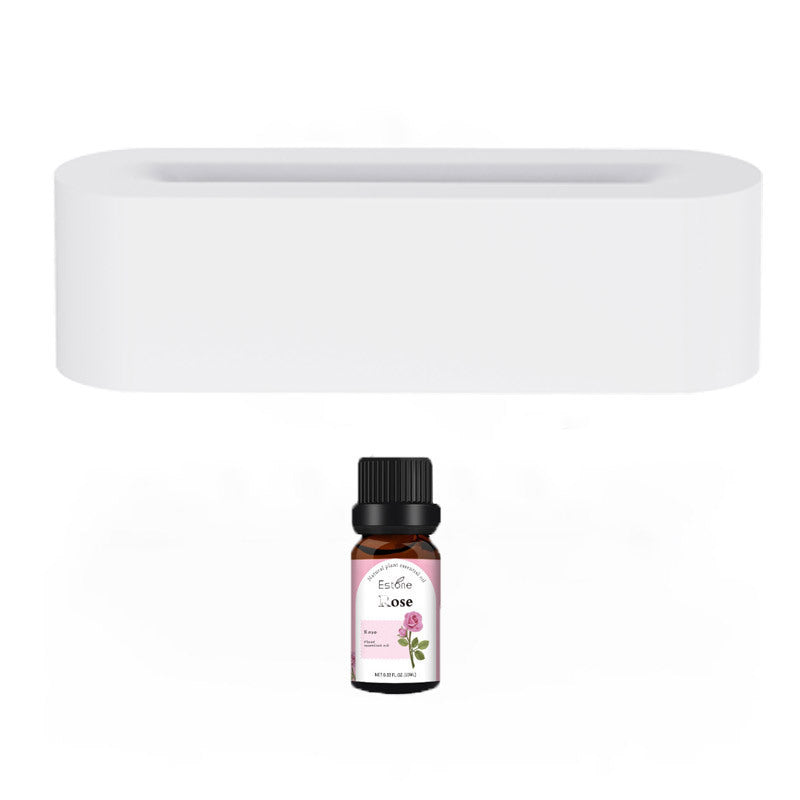 Stylish aroma diffuser with white body and essential oil bottle in foreground