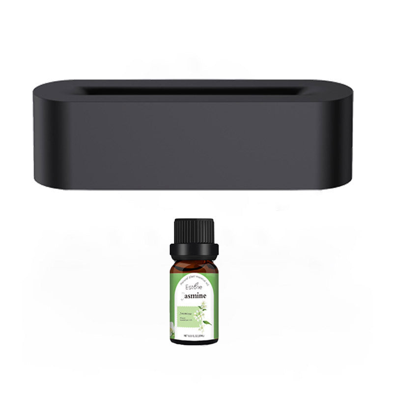 Sleek black aroma diffuser with LED lights and a bottle of essential oil placed next to it, providing a relaxing atmosphere.